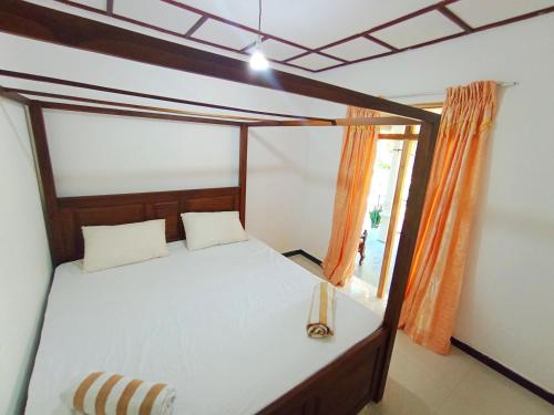 Un dormitorio con una cama con dosel y una ventana. en Benefit Villa Mirissa, en Mirissa
