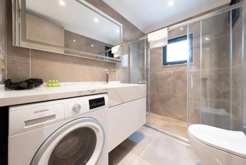 Un baño con lavadora y lavabo. en Mayer Skycon Residence in Beşiktaş 2, en Estambul