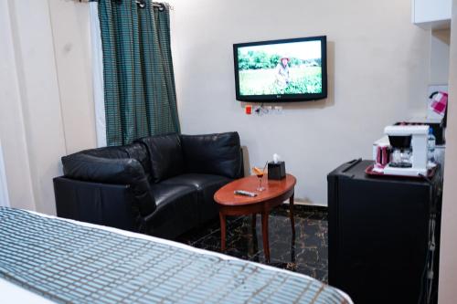 a room with a couch and a chair and a tv at EKA ELITE HOTEL in Lomé