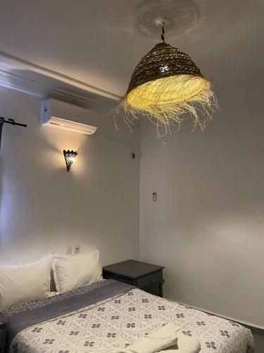 a bedroom with a bed and a chandelier at Etoile d Or Ksar Ait Ben Haddou in Aït Ben Haddou