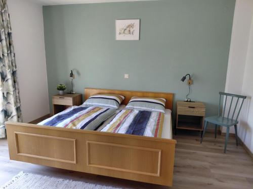 a bedroom with a bed with a wooden frame and a chair at Ferienhaus Gioia in Schruns-Tschagguns