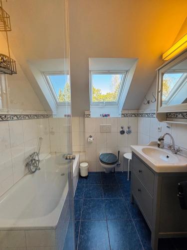 a bathroom with a tub and a toilet and a sink at Villa Luisa in Timmendorfer Strand