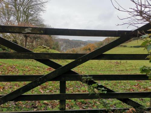 a wooden fence with a field in the background at the Nook, Romantic cottage for two, Dartmoor and SW coast in Bovey Tracey