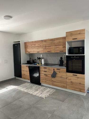 a kitchen with wooden cabinets and a black appliances at Chata Koniareň in Ulič