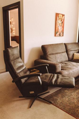 a chair sitting in a living room next to a couch at Apartament Warmiński Port 50m od jeziora in Olsztyn
