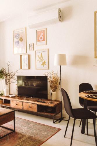 a living room with a television and a table and chairs at Apartament Warmiński Port 50m od jeziora in Olsztyn