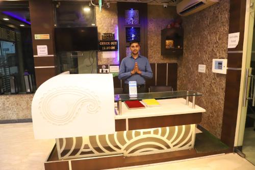 a man is standing in a room with a podium at Hotel R K Palace - Simple Stay Royal Comfort in Jaipur