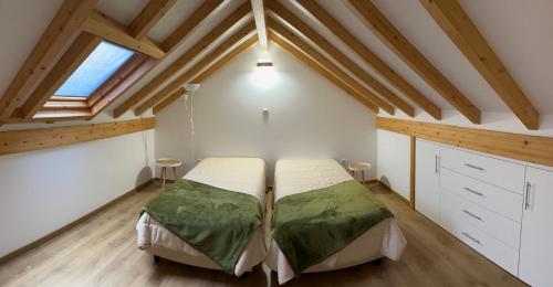 a bedroom with two beds in a attic at Jardins do Barão in Leiria