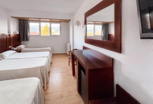 a room with two beds and a mirror at Puigcerda Park Hotel in Puigcerdà