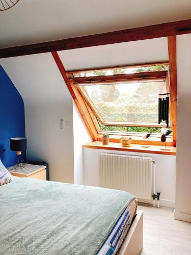 une chambre avec un lit et une fenêtre dans l'établissement Menhirs et Marées à Carnac Plage, à Carnac