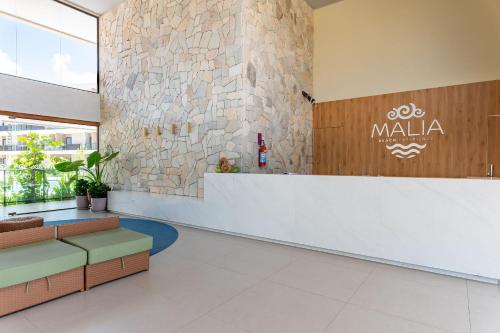 eine Lobby eines Einkaufszentrums mit Aania-Schild an der Wand in der Unterkunft Malia Beach Experience Muro Alto Porto de Galinhas por Brevelar in Ipojuca