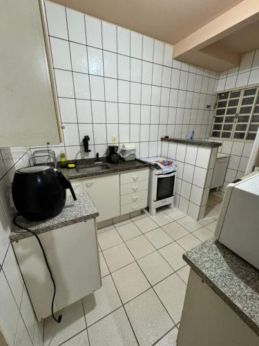 a kitchen with a black pot on a counter at Apto Gabriel IBRANTINA PENNA in Uberaba