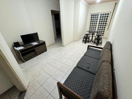 a living room with a couch and a tv at Apto Gabriel IBRANTINA PENNA in Uberaba