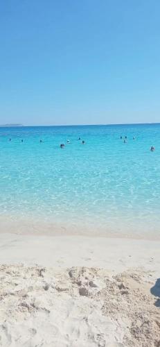 a group of people swimming in the ocean at Villa Best Holiday- breathtaking sea views, amazing garden, private pool, BBQ, next to CORAL BAY, Lower Peyia, Paphos in Peyia