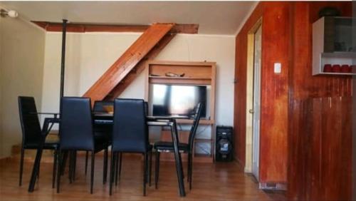 Un comedor con mesa y sillas y una escalera. en Cielo de Cabaña Inquillay, en San Pedro de Atacama