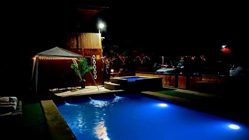 Una gran piscina azul en un patio por la noche. en Cielo de Cabaña Inquillay, en San Pedro de Atacama
