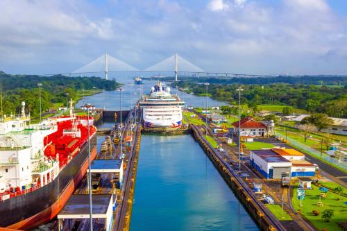 a cruise ship docked in a river with a bridge in the background at Hotel Caracas in Panama City