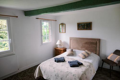 une chambre avec un lit avec deux oreillers bleus dessus dans l'établissement Chambres d'hôtes Le Clos des Chaumes, proche Honfleur, à Saint-Maclou