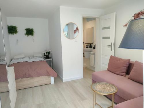 a small bedroom with a bed and a couch at Zacisze Leśne nad Pilicą in Spała