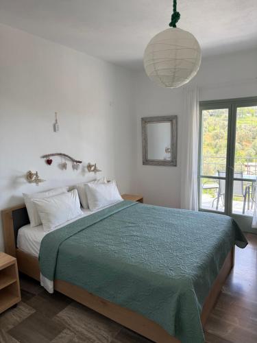 a bedroom with a bed with a green comforter at Skiathos Country Studios in Skiathos Town