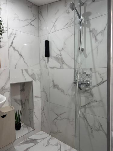 une douche avec une porte vitrée dans une salle de bain dans l'établissement Studio meublé, à Marseille