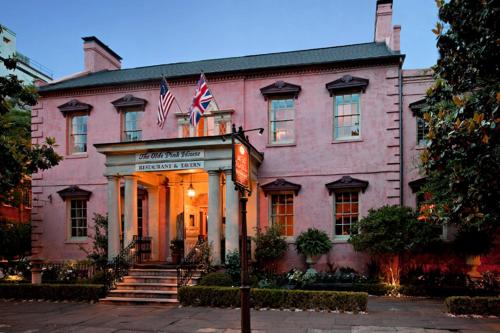 a large pink building with two american flags on it at Planters Inn on Reynolds Square in Savannah