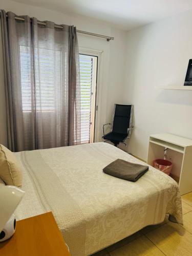 维辛达里奥Habitación Privada May con balcon的一间卧室，配有一张床、一张桌子和一把椅子
