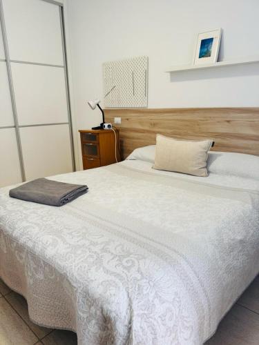 维辛达里奥Habitación Privada May con balcon的卧室配有白色的床和木制床头板