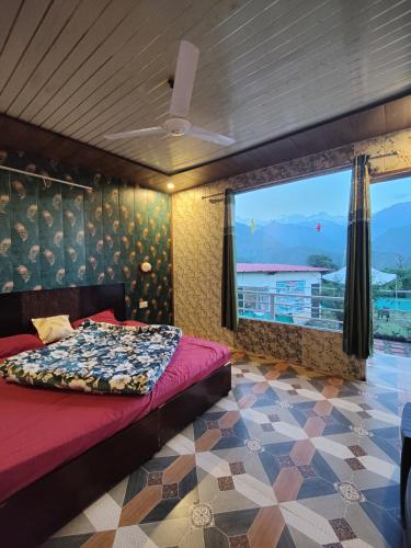 a bedroom with a bed and a large window at Kedar Avnita Resort in Gupta Kāshi