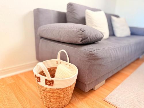 a living room with a couch and a basket at Le Duplex des Tulipes - Parking included - Haguenau in Haguenau