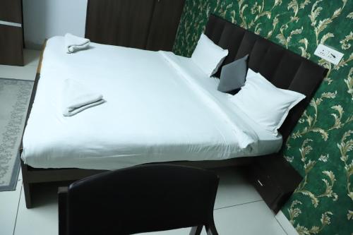 a bedroom with a large bed and a chair at Hotel R K Palace - Simple Stay Royal Comfort in Jaipur