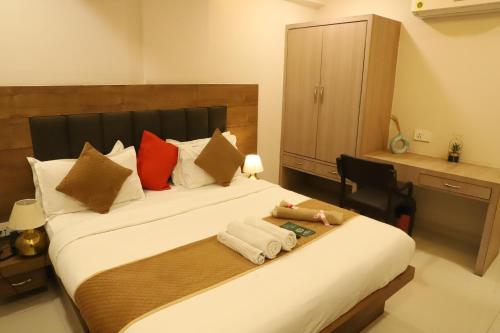 a bedroom with two beds with pillows and a desk at Hotel R K Palace - Simple Stay Royal Comfort in Jaipur