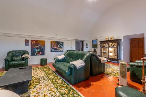 a living room with green leather furniture and a table at Convento da Orada - Monsaraz in Monsaraz