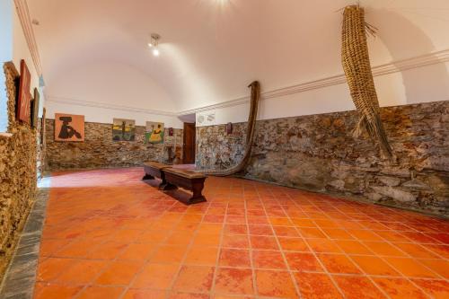an empty room with a bench and a wall with paintings at Convento da Orada - Monsaraz in Monsaraz