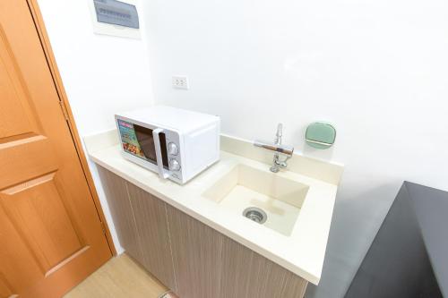 a bathroom with a microwave and a sink at Tropical 2BR with Pool & Walk to Beach entry to white sand in Lapu Lapu City
