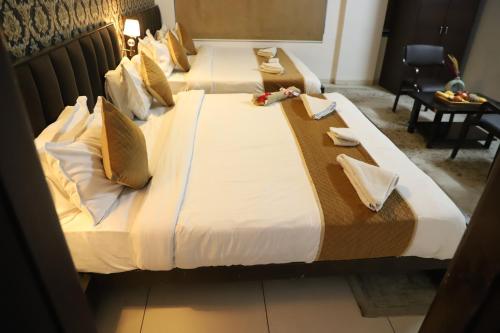 two beds in a hotel room with flowers on them at Hotel R K Palace - Simple Stay Royal Comfort in Jaipur