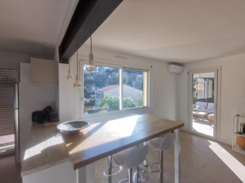 une cuisine avec un comptoir et une grande fenêtre dans l'établissement Le Poséidon T2 Vue mer, à Carry-le-Rouet