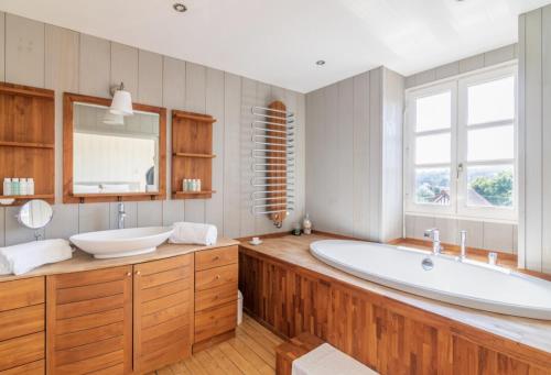 La grande salle de bains est pourvue d'une grande baignoire et d'un lavabo. dans l'établissement Beautiful historic villa close to Deauville, à Villers-sur-Mer