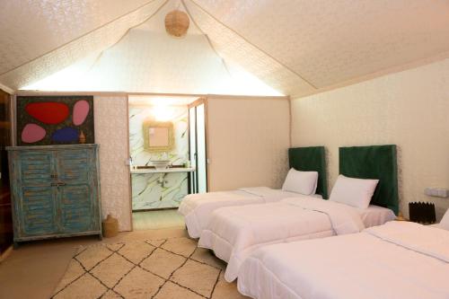 a room with three beds and a mirror at Kal Tenere Agafay Luxury Camp in El Karia