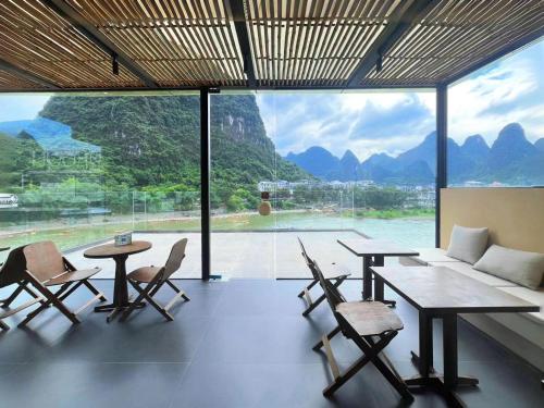 a room with tables and chairs and a large window at Yangshuo Lutong Hotel in Yangshuo
