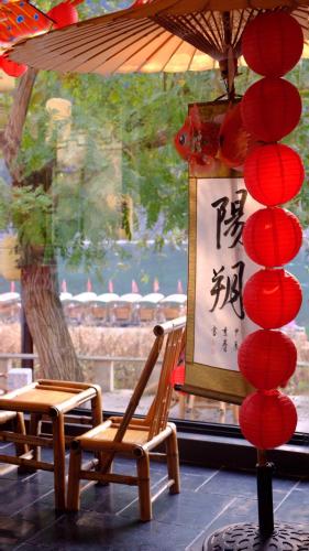 a chair under an umbrella next to a window at Yangshuo Lutong Hotel in Yangshuo