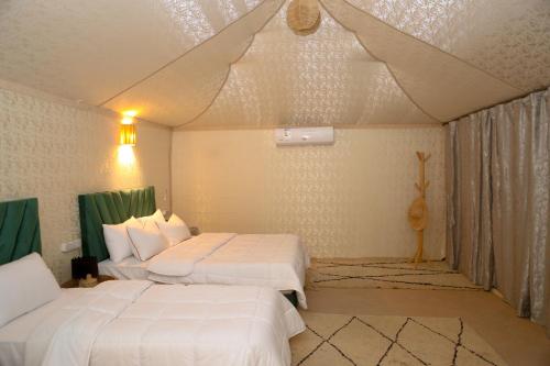 a bedroom with two beds in a room at Kal Tenere Agafay Luxury Camp in El Karia