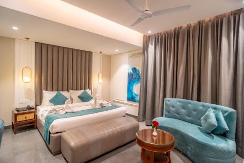 een slaapkamer met een bed en een blauwe stoel bij Hotel MJ Residency in Dehradun