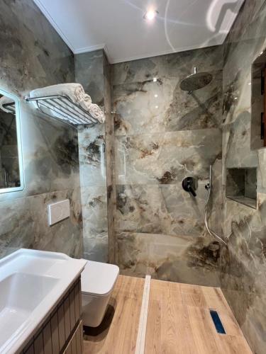 a bathroom with a toilet and a sink at Kamberi Hotel & Apartments in Velipojë