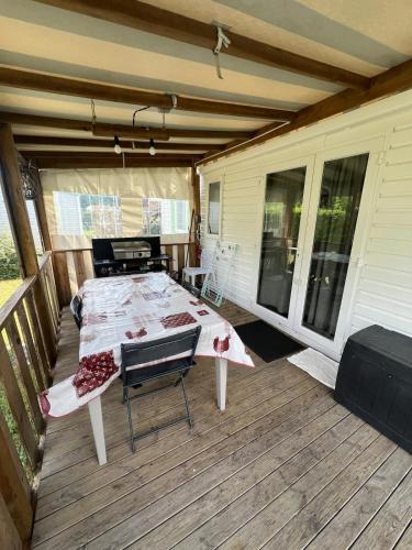 - une véranda avec un lit sur une terrasse dans l'établissement 421 Mobil home domaine de la forge, à La Teste-de-Buch