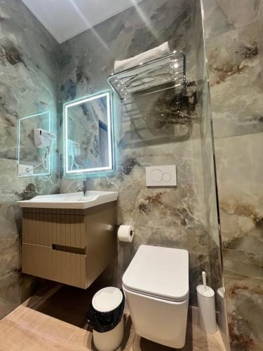 a bathroom with a toilet and a sink at Kamberi Hotel & Apartments in Velipojë