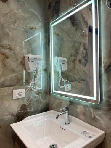 a bathroom with a sink and a mirror at Kamberi Hotel & Apartments in Velipojë