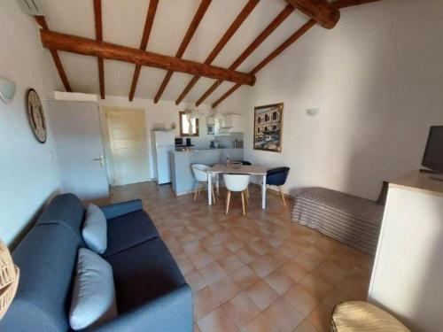 un salon avec un canapé bleu et une table dans l'établissement Mini villa proche Porto Vecchio, à Porto-Vecchio