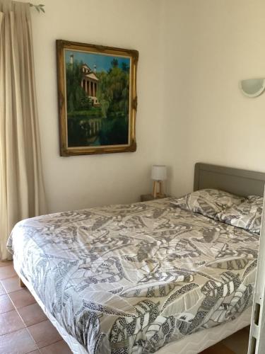 un lit dans une chambre avec un tableau sur le mur dans l'établissement Mini villa proche Porto Vecchio, à Porto-Vecchio