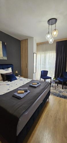 a large bed with two towels on top of it at Apartmani blue i green in Bugojno